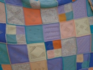 A closeup of Gill’s blanket showing the many different patterned squares.